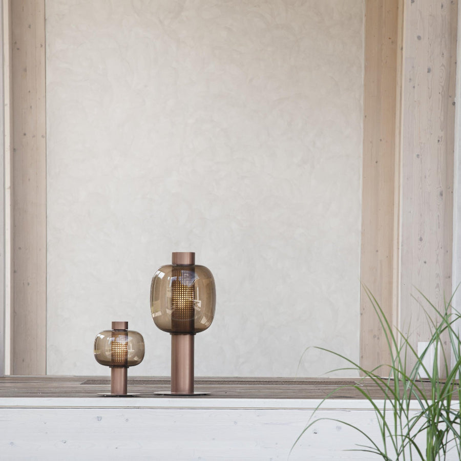 bonbori on a surface with a light-colored wall and wooden frame in the background.