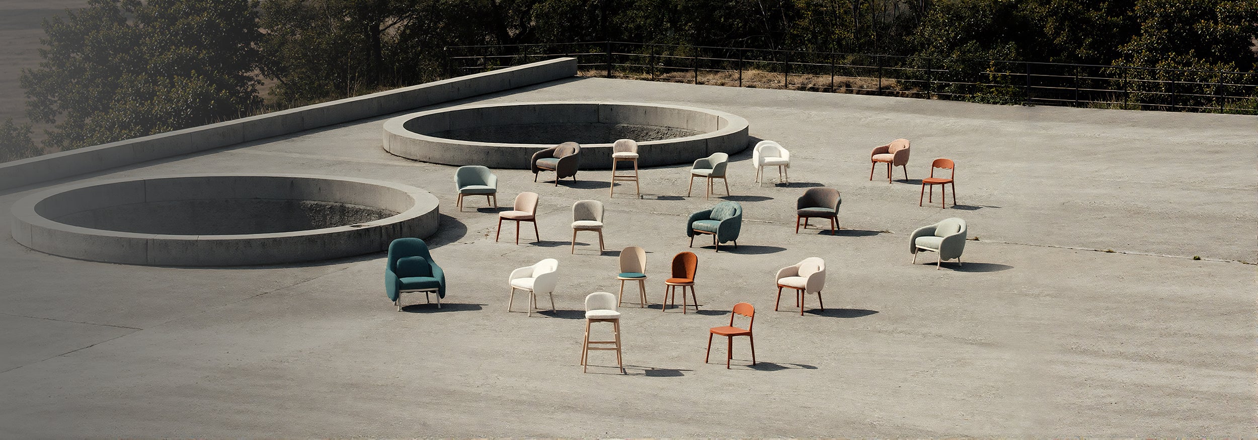 Outdoor setting with chairs and tables arranged on a concrete surface with a natural background