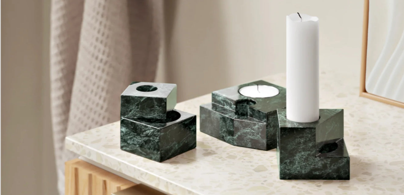 Green marble candle holders on a ceramic surface in bathroom