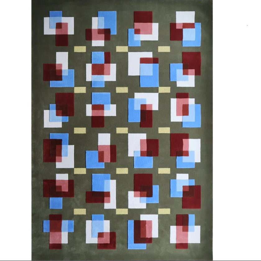 Geometric patterned rug with red, blue, and white squares on a green background