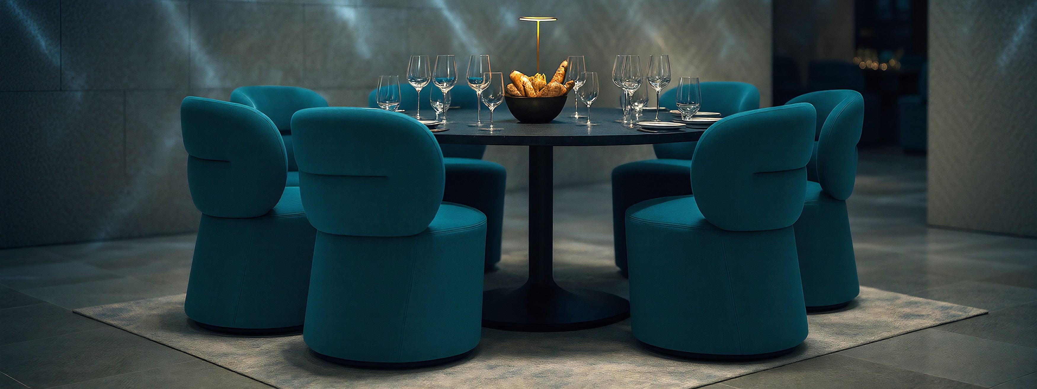 Modern dining setup with blue chairs and a black table in a dimly lit room.