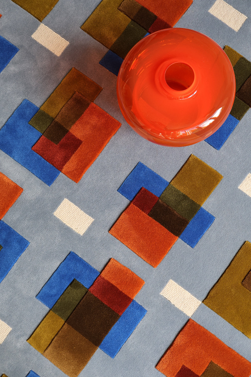 Geometric patterned rug with a bright orange lamp on top