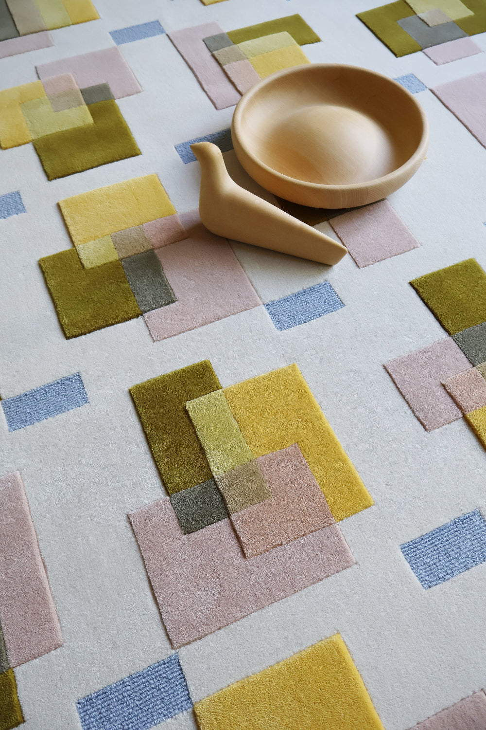 Colorful geometric-patterned rug with a ceramic bowl on top