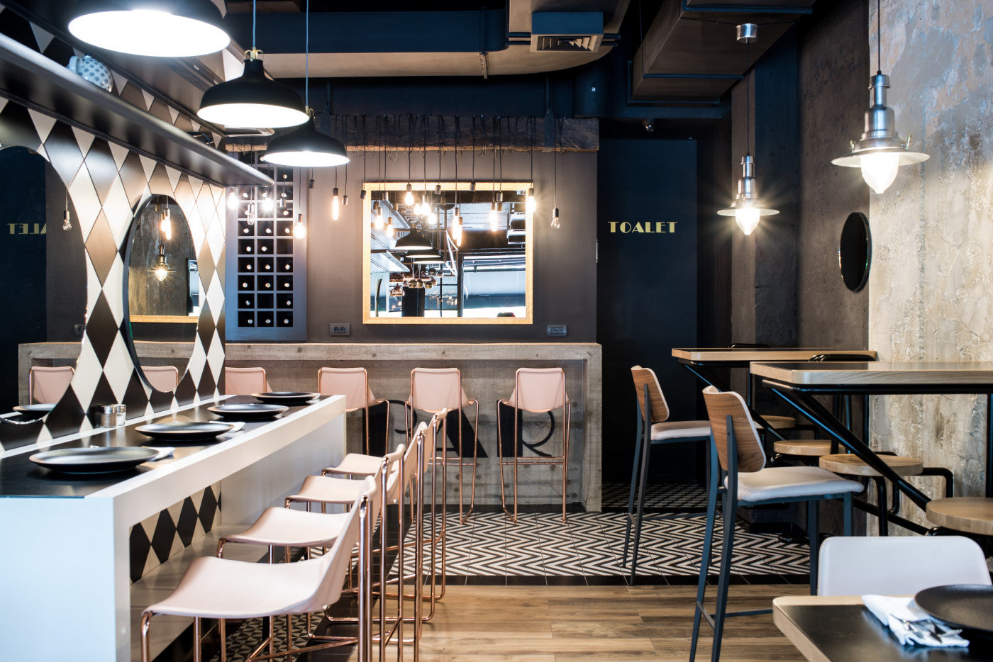 Modern restaurant interior with bar stools, tables, and decor.