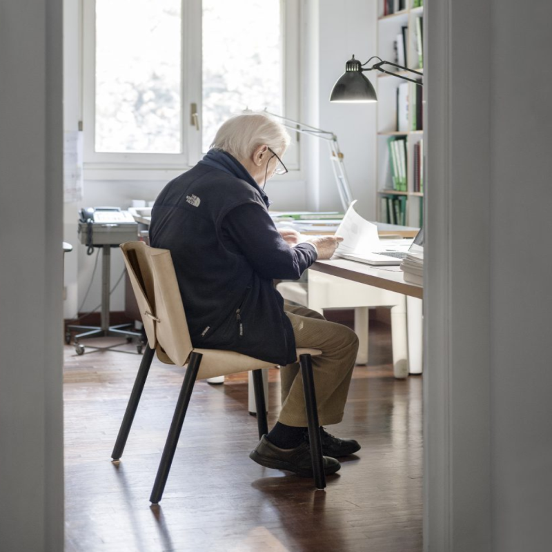 Man sitting on Natural 1085 Edition Italian Leather Chair by Kristalia