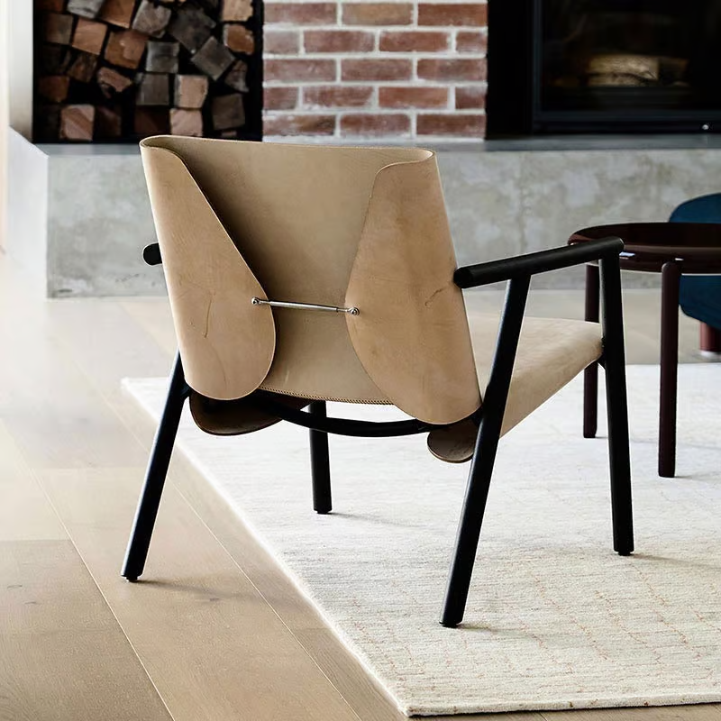 1085 Edition Lounge Armchair in natural leather by Italian brand Kristalia near fireplace