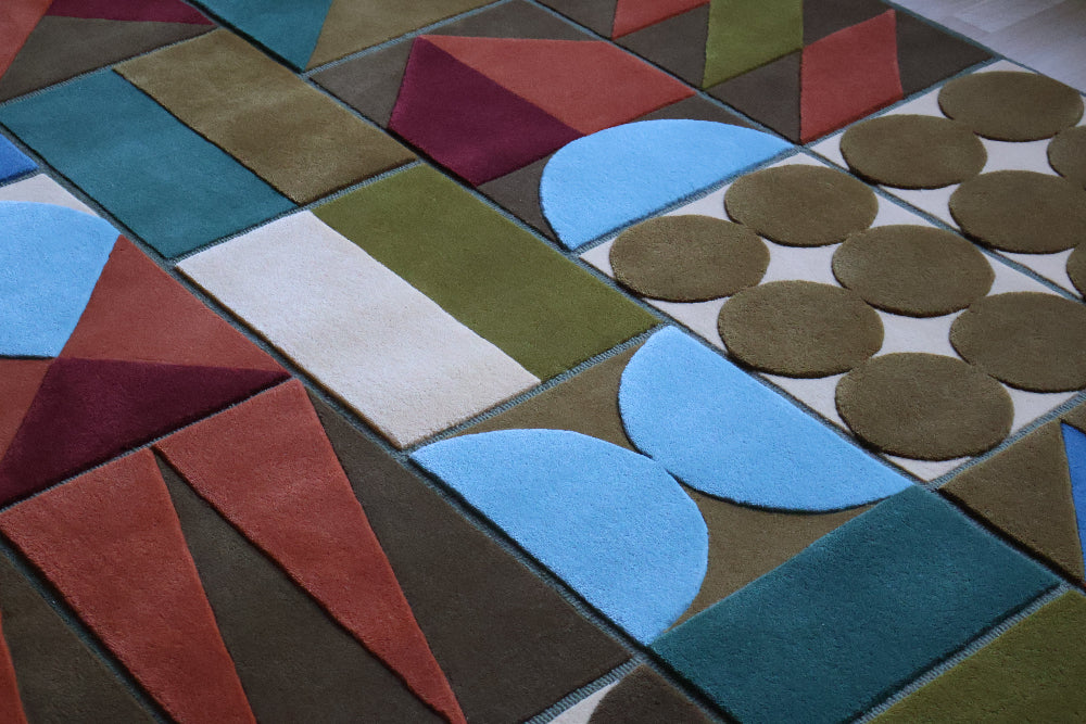Colorful geometric-patterned rug with various shapes and colors.