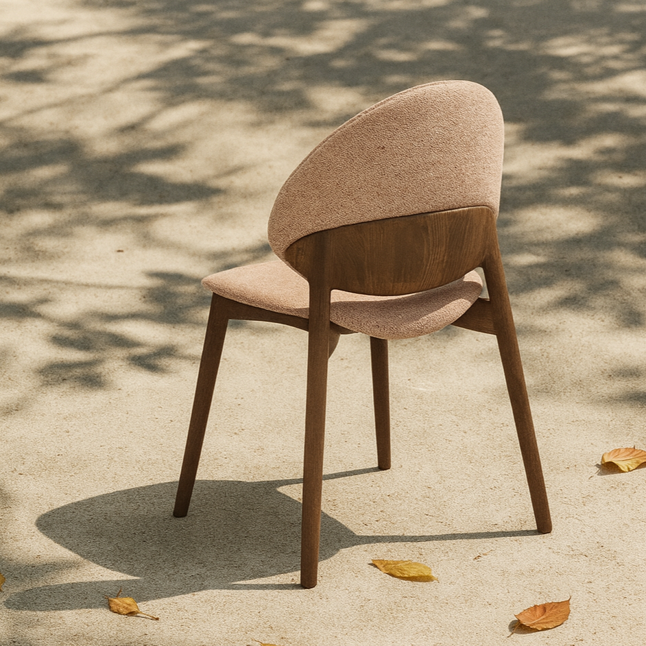 contemporary dining chair with wooden legs on a outdoor surface with leaf shadows