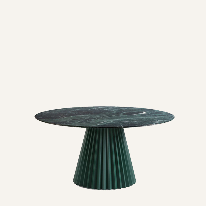Round marble table with pleated green base on a white background