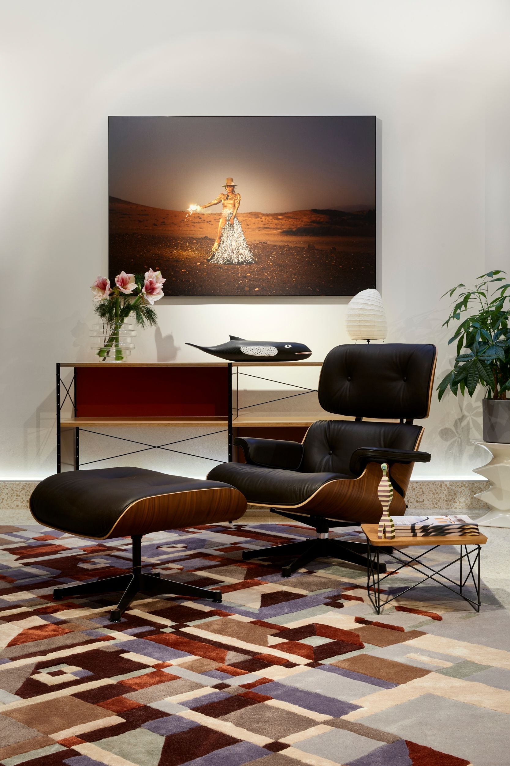 Stråler Red Brown  Volver Modern living room with a patterned rug, black chair, and artwork on the wall.