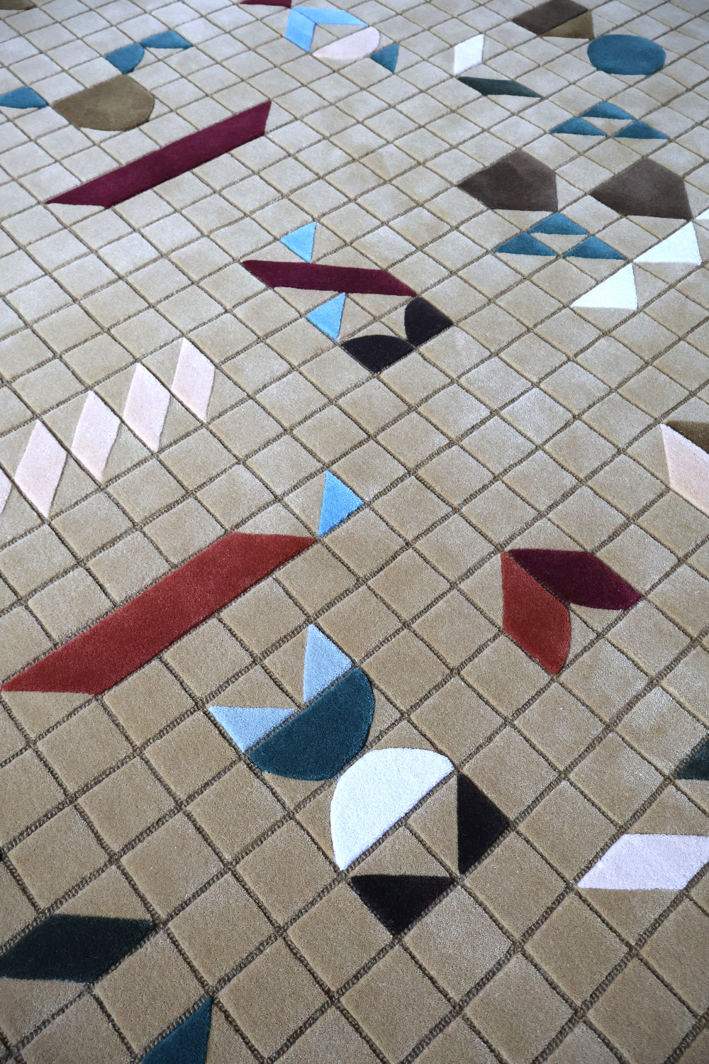 Geometric patterned tile floor with multicolored shapes on a beige background