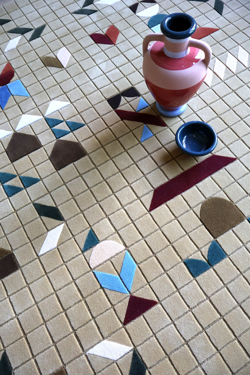 Decorative tile pattern with a ceramic pitcher on a rug
