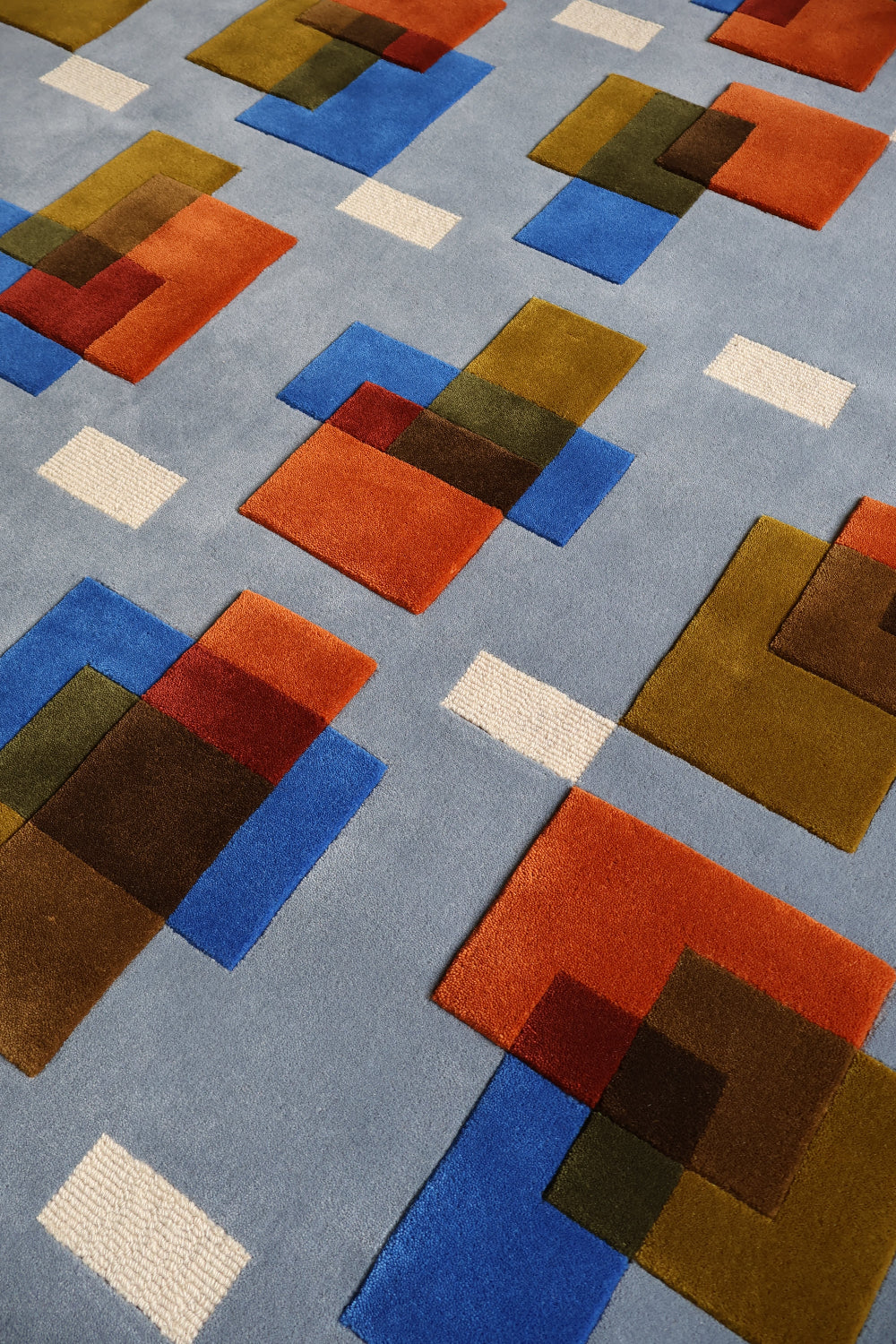 Geometric patterned rug with colorful squares on a gray background